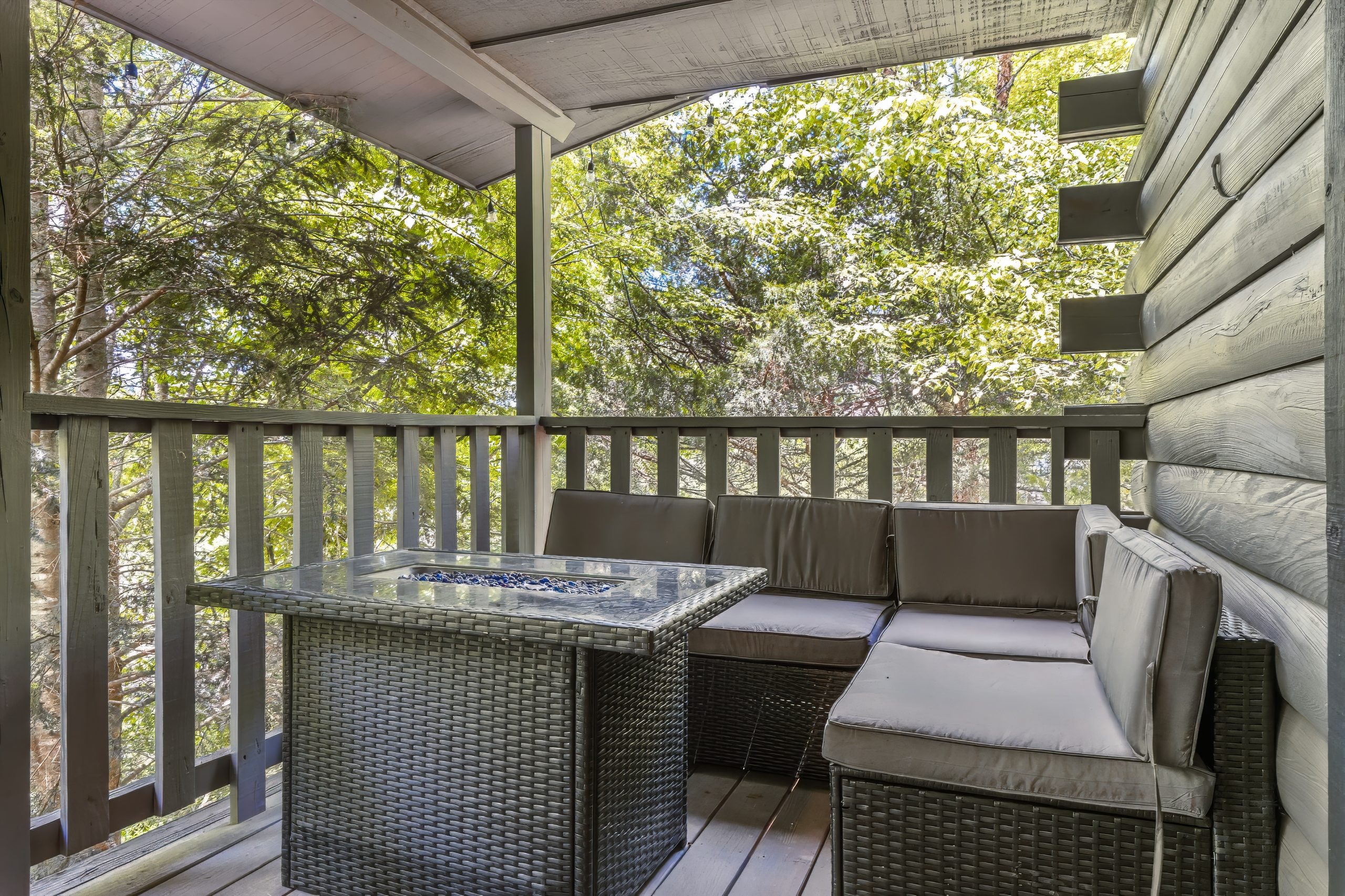 Wooded deck seating area at Adventure Awaits cabin