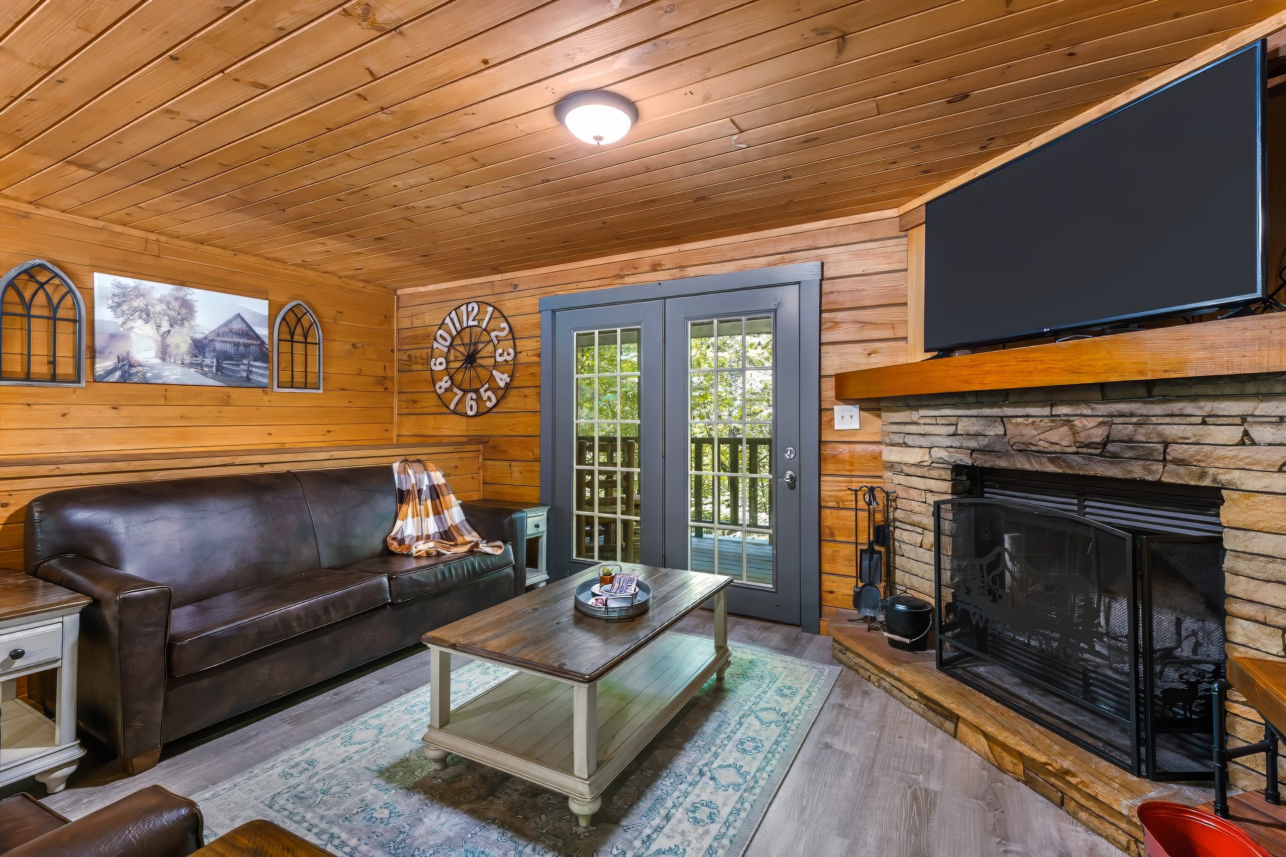 Wood-paneled living room with fireplace at Adventure Awaits cabin